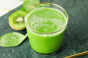 Glass of healthy green smoothie on table, closeup