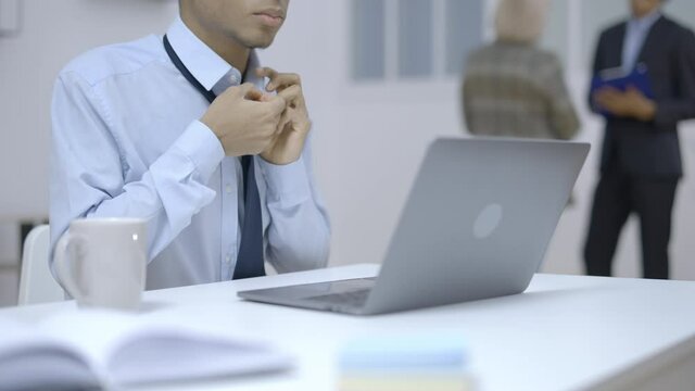 Office employee unbuttoning shirt breathing heavily, feeling bad at work, health