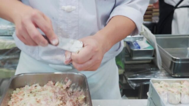 Making Dim Sum. Chef preparing Dim sum dumplings. Kneading the dough and making Chinese dim sum pork dumplings. Dim sum dumplings it's the most popular and famous food in China. also Xiao long bao.