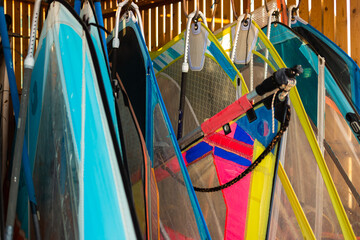 Windsurfing sails storage on a beach watersports facility. Surfer boards on shelf lie  under the...