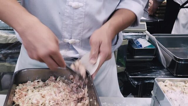 Making Dim Sum. Chef preparing Dim sum dumplings. Kneading the dough and making Chinese dim sum pork dumplings. Dim sum dumplings it's the most popular and famous food in China. also Xiao long bao.
