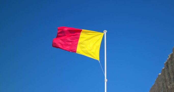 Red And Yellow Flag Waving In The Strong Wind.  Closeup View - DCi 4K Resolution