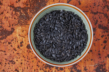 a pile of fresh roasted black sunflower seeds