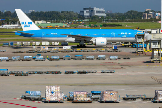 KLM Boeing 777 airliner between the air freight at the gate at Amsterdam Schiphol international airport.