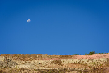 Paisaje rocoso montañoso con cielo azul profundo y la luna en las sierras de Córdoba