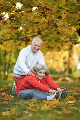 Naklejka na ściany i meble portrait of beautiful caucasian senior couple in the park exercising