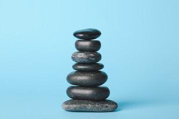 Stack of spa stones on color background