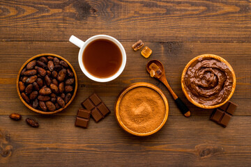 Cup of hot chocolate with coffee and cocoa beans, top view