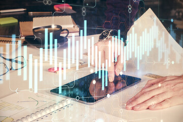 Double exposure of man's hands holding and using a digital device and forex graph drawing. Financial market concept.