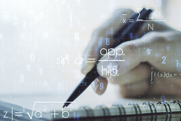 Creative scientific formula hologram with woman hand writing in notepad on background, research concept. Multiexposure