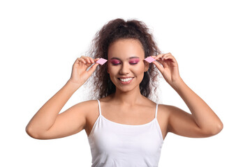 Beautiful young African-American woman with makeup sponges on white background