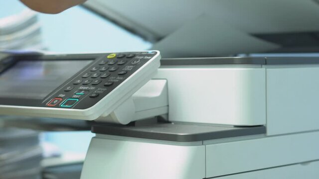Hand of woman is using a photocopier to copy documents.