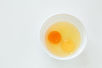 raw broken chicken eggs. egg yolks in a white plate
