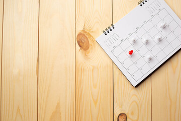 Calendar on wooden table with copy space, business meeting schedule, trip planning or project goals and reminder ideas.