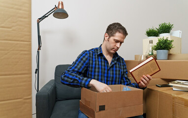 Man unpacking his books in new apartment.