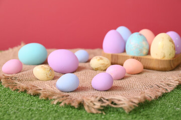 Fototapeta na wymiar Beautiful Easter eggs on grass against color background