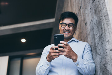 asian man work using cell phone hand holding mobile texting message contact us.chatting,search...