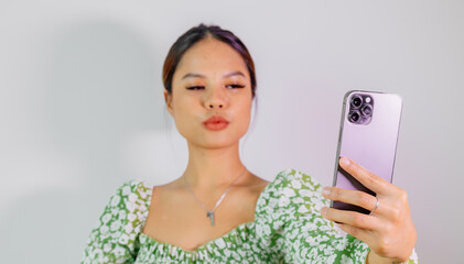 Pretty asian girl take a self portrait with her smart phone. Thai girl selfie.