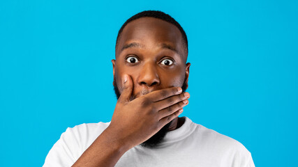 Shocked African American Guy Covering Mouth Over Blue Background, Panorama