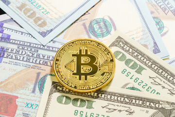 Golden Bitcoins coin and  US banknotes of one hundred dollars