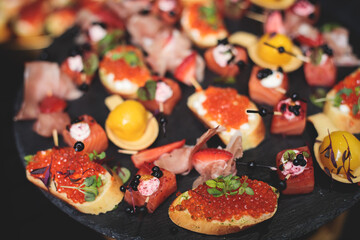 Catering table, beautifully decorated banquet with variety of with different food snacks and appetizers on corporate birthday party event or wedding celebration, seafood, canape, delicatessen setting