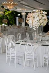 Festive wedding table setting with flowers, napkins, cutlery, glasses, bright summer table decor. Wedding decor