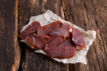 Spicy beef jerky on vintage wooden background. Close-up, background image