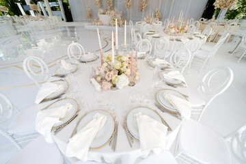Festive wedding table setting with flowers, napkins, cutlery, glasses, bright summer table decor. Wedding decor