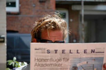 Mann liest Zeitung mit Stellenanzeigen