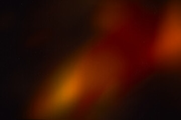 Blur colorful warm rainbow light leaks on black background with dust texture. Defocused abstract...