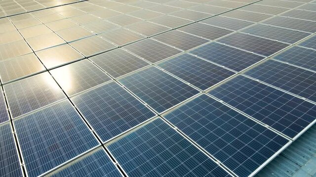 Closeup of surface of blue photovoltaic solar panels mounted on building roof for producing clean ecological electricity. Production of renewable energy concept.
