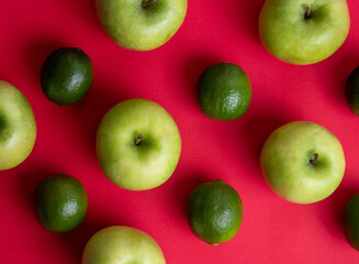Persian lime (Limão-taiti) and Green Apples on red background