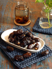 A plate of dried dates and dates infused water in glass jar. Healthy and refreshing. Very popular during Ramadan fasting month. High angle view.