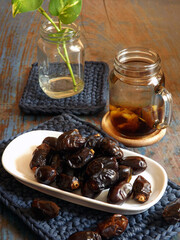 A plate of dried dates and dates infused water in glass jar. Healthy and refreshing. Very popular during Ramadan fasting month. High angle view.