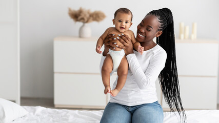 Black woman playing with her cute little infant