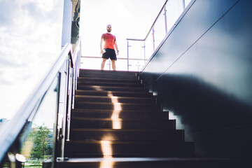 Sporty man standing on stairway