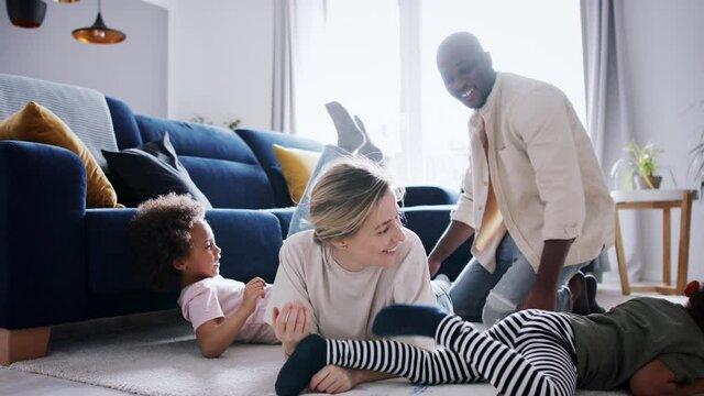 Multi ethnic family with two small children having fun at home.