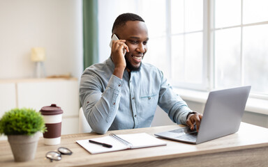 Obraz premium Happy African American Businessman Talking On Cellphone In Modern Office