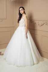 Fototapeta premium Fashion bride in gorgeous wedding dress studio portrait. Beautiful model with bridal makeup and hairstyle in marriage lace dress.