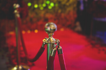 View of red carpet between ropes and golden barriers on a luxury party entrance, cinema premiere...