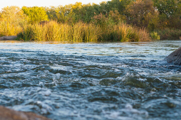 Background, top view, rapid flow river with dark blue water and white foam waves