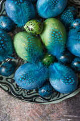 Painted eggs on the Easter table with feathers