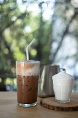 Iced Mocha coffee topping with milk foam and served with milk foam in glass