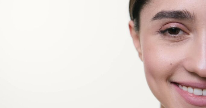 Half face of beautiful woman smiling over white background