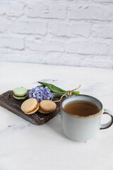 Obraz na płótnie Canvas Breakfast tea with macaroons on a wooden background with a hyacinth flower and a beautiful saucer. vertical orientation