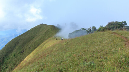 People or traveler walk on the Mountain hill with grass field with sea of fog or white clouds at 
