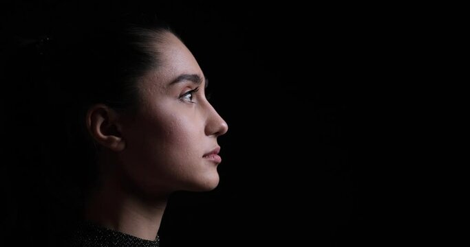 Profile face of thoughtful woman on black background