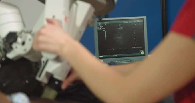Modern lithotripter to break up kidney stones. Lithotripsy for kidney and ureteral stones. Back view of woman doctor, using ultrasound scan to determine the stone position before the lithotripsy.