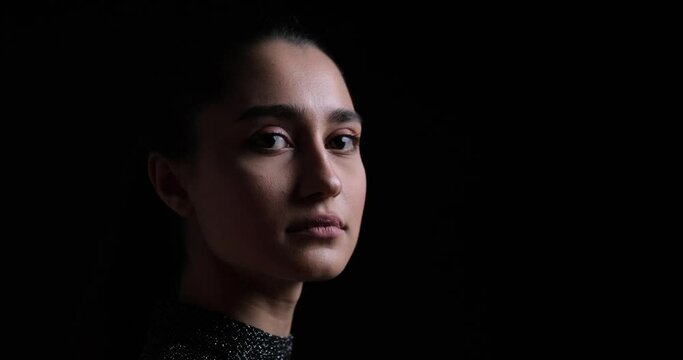 Portrait of serious woman in thoughts over black background