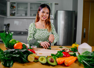 Asian girl cooking healthy vegetarian and vegan food, vegetables and fruits in the kitchen, healthy lifestyle